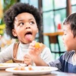playful kids eating snack in cafe restaurant
