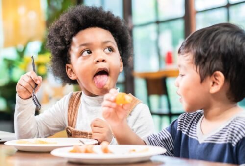 playful kids eating snack in cafe restaurant