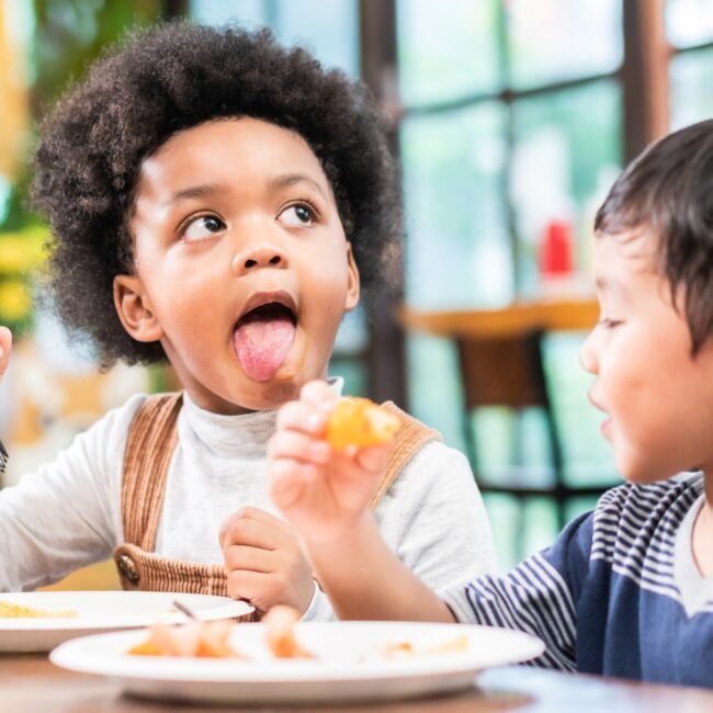 playful kids eating snack in cafe restaurant