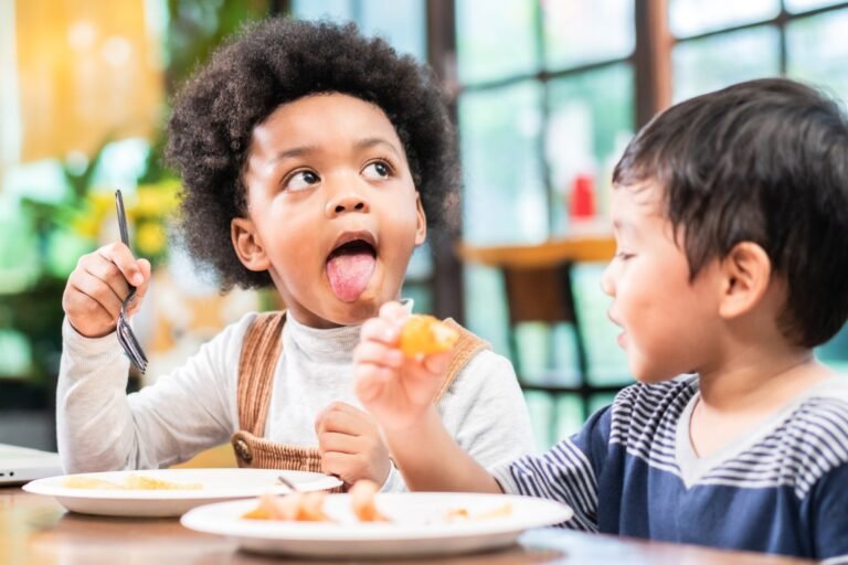 playful kids eating snack in cafe restaurant